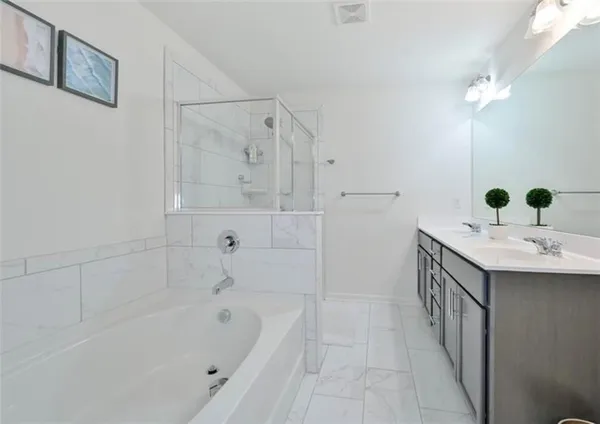 a bathroom with a tub sink and mirror