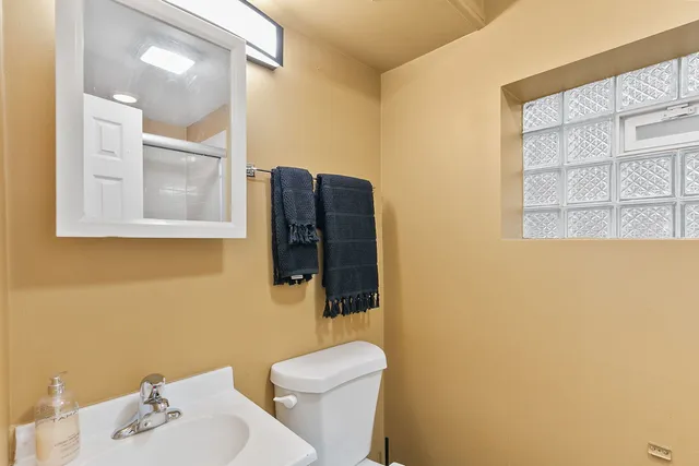 a bathroom with a sink mirror vanity and toilet