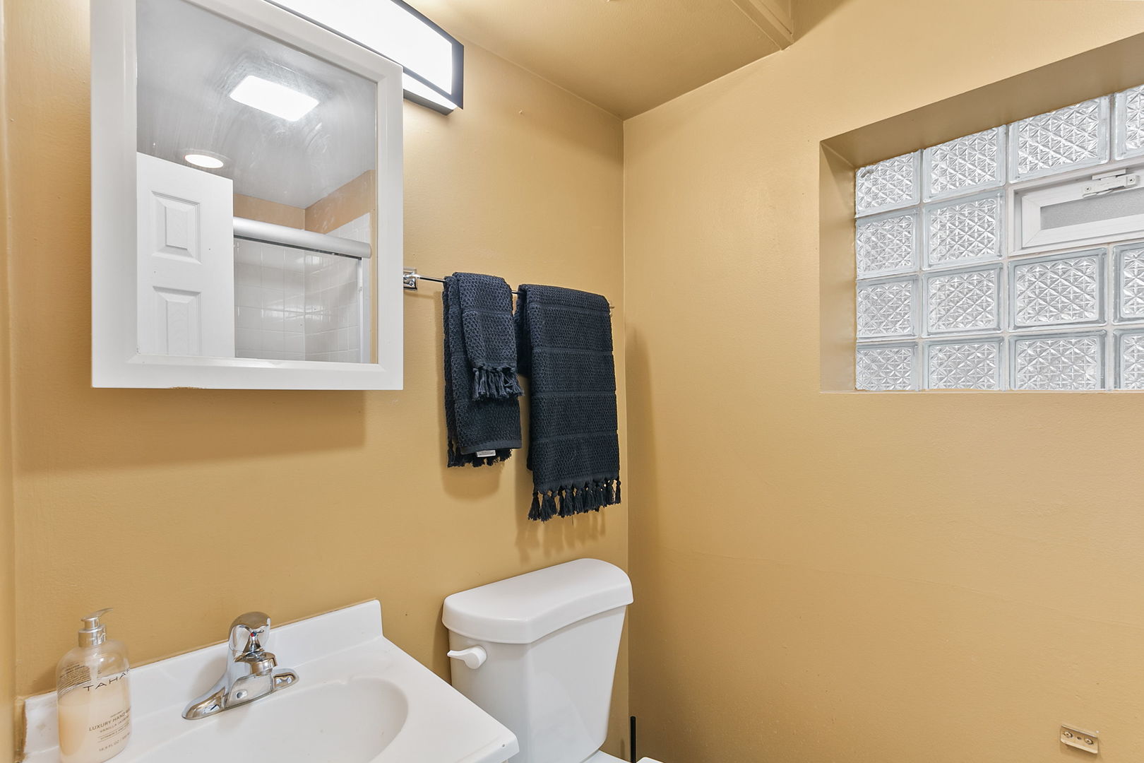 15221 Oak Street Dolton, IL 60419 - Photo 14 of 16 a bathroom with a sink mirror vanity and toilet