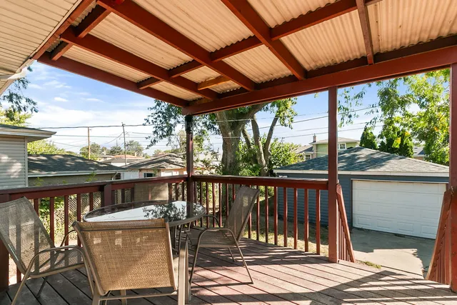 a view of a balcony with chairs and wooden floor