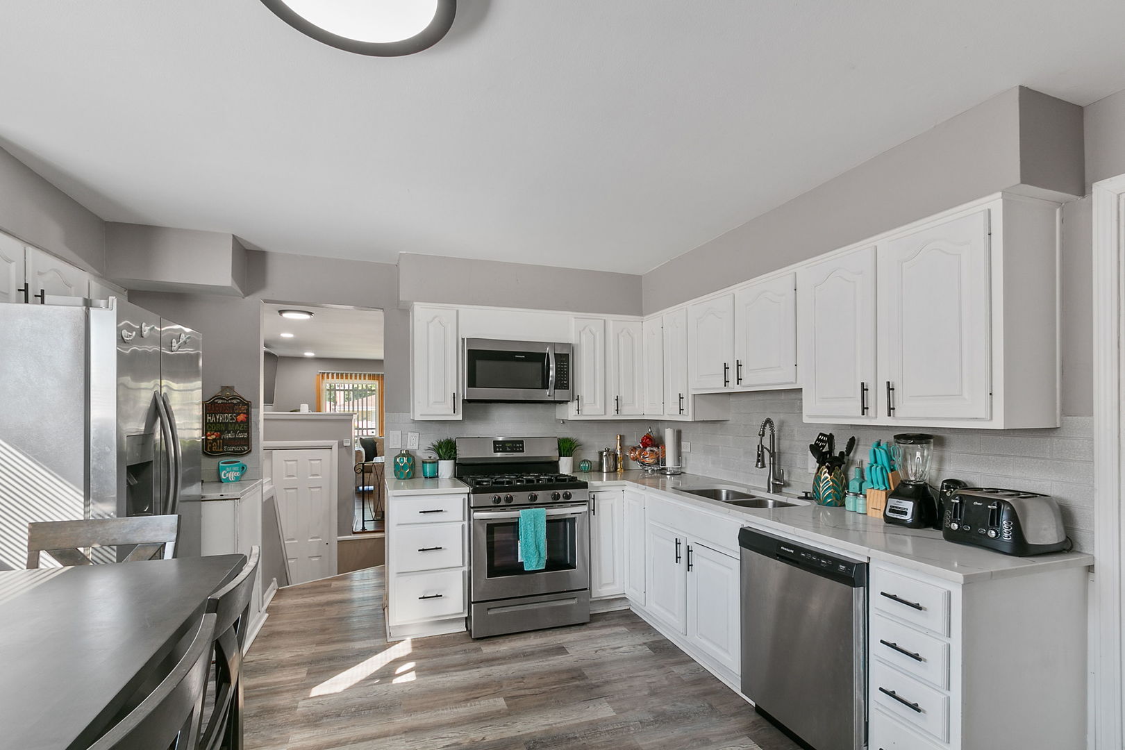15221 Oak Street Dolton, IL 60419 - Photo 6 of 16 a kitchen with stainless steel appliances granite countertop a stove top oven a sink dishwasher and a refrigerator with white cabinets