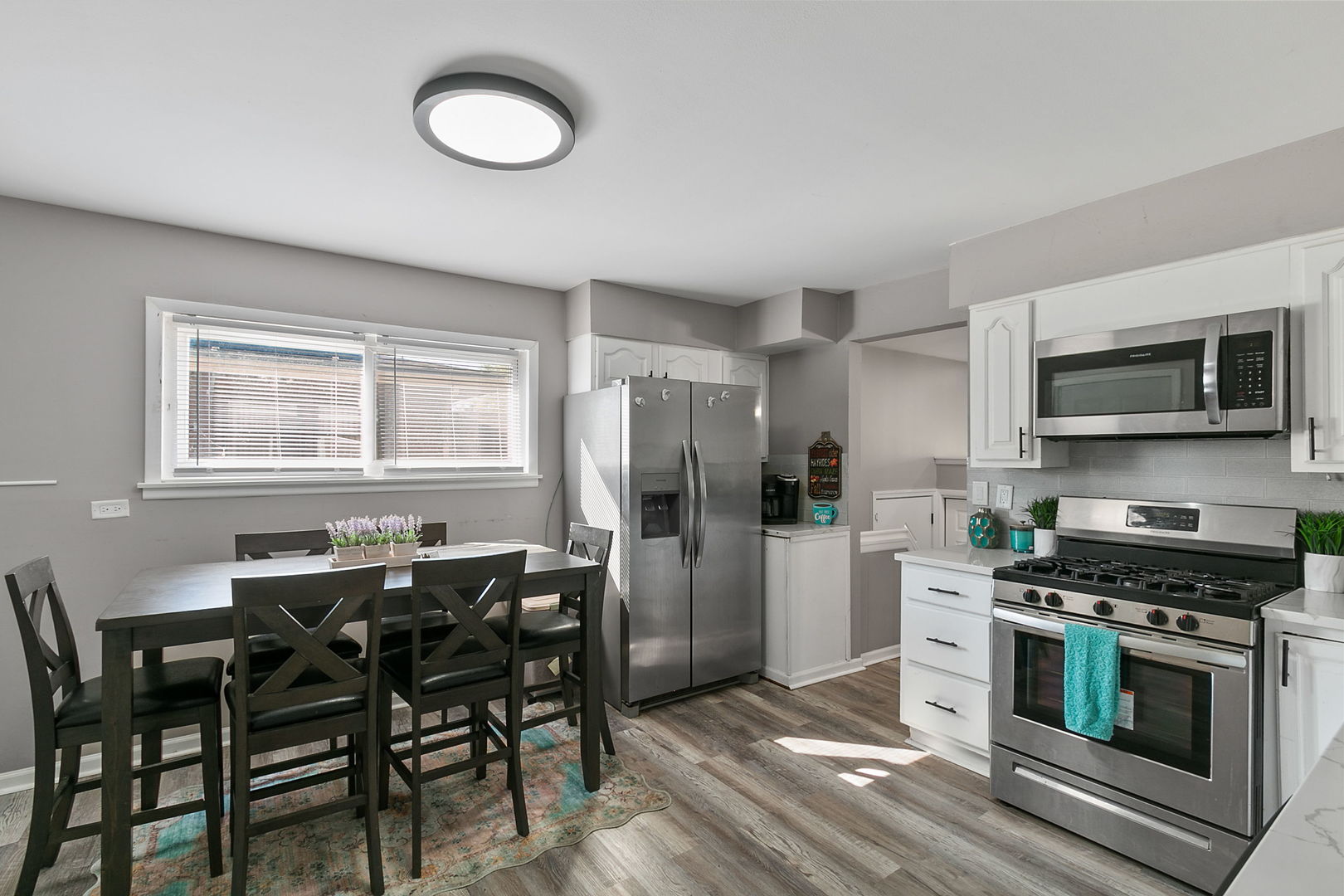 15221 Oak Street Dolton, IL 60419 - Photo 7 of 16 a kitchen with stainless steel appliances a stove a refrigerator and a dining table