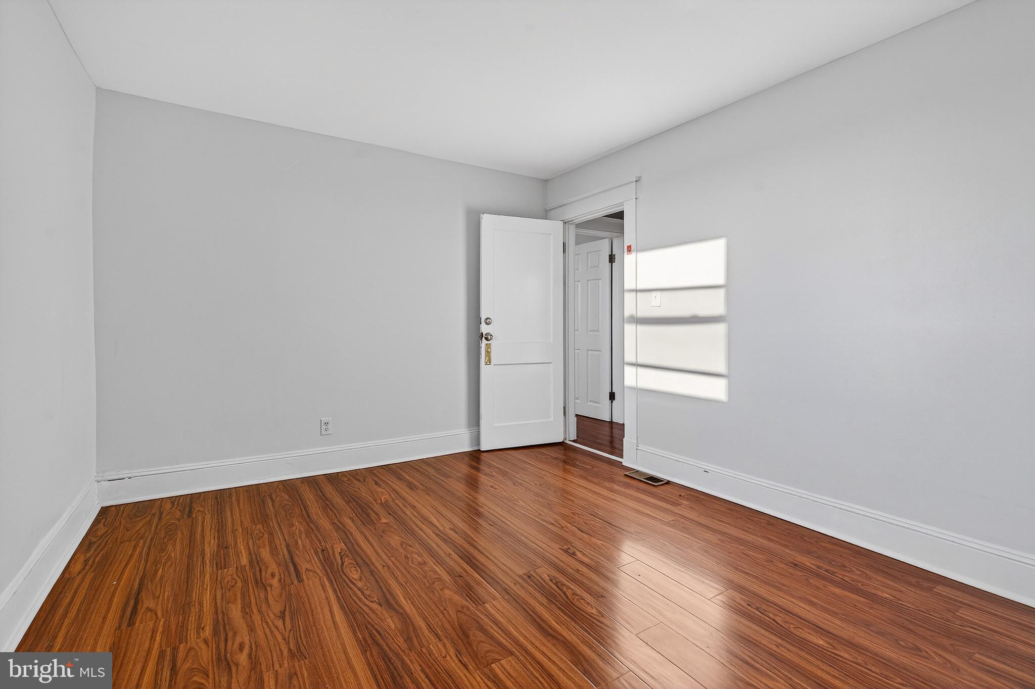 511 47th Street Baltimore, MD 21224 - Photo 19 of 44 a view of an empty room with wooden floor and window