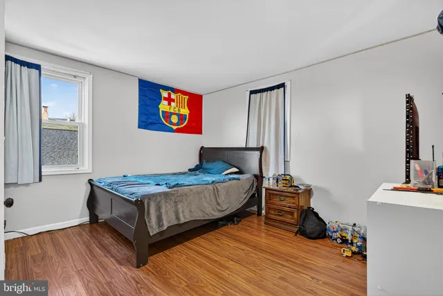 a view of an empty room with wooden floor and window
