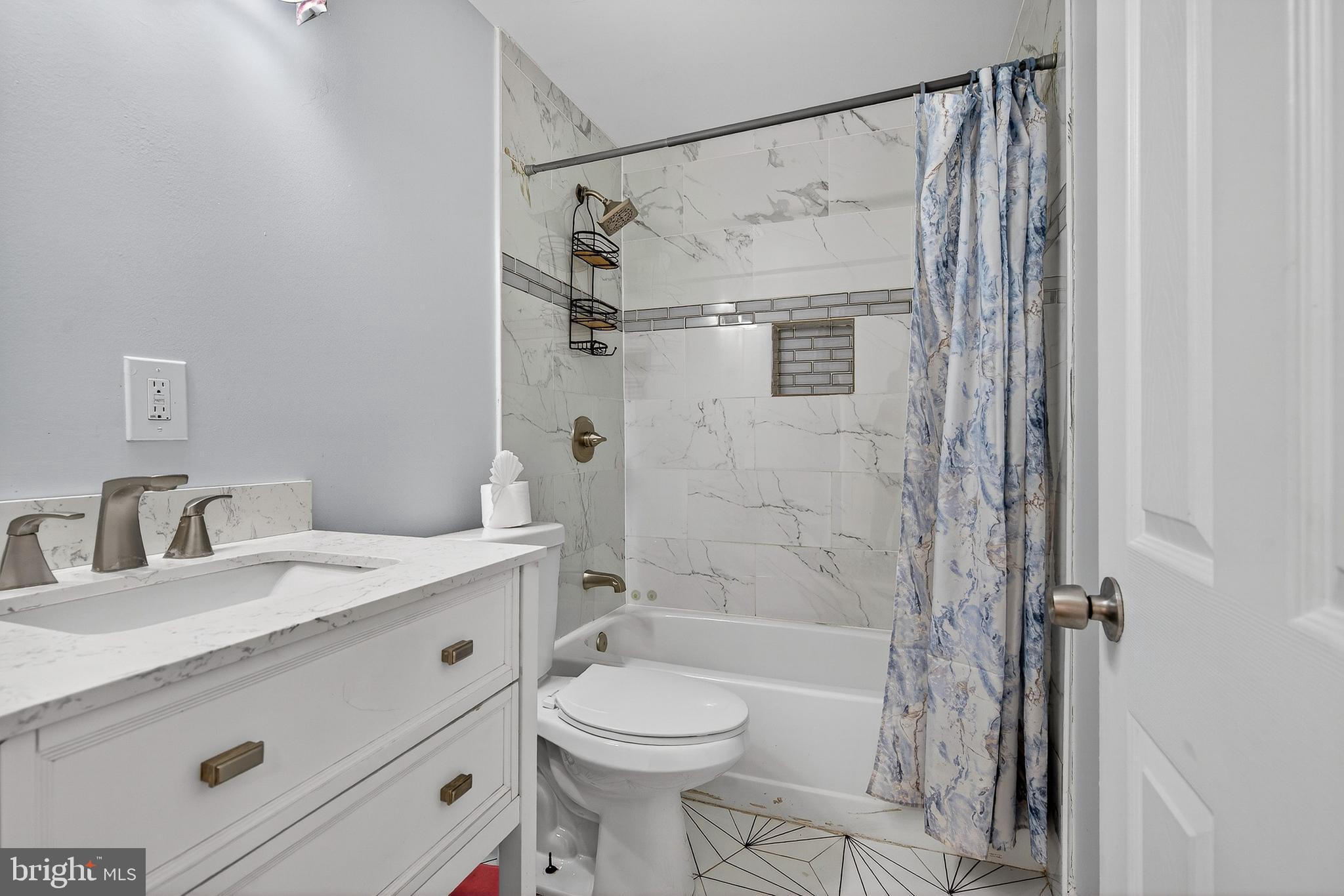 511 47th Street Baltimore, MD 21224 - Photo 36 of 44 a bathroom with a granite countertop sink toilet and shower