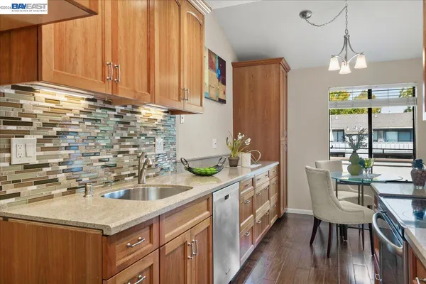 a kitchen with stainless steel appliances a sink a table and chairs