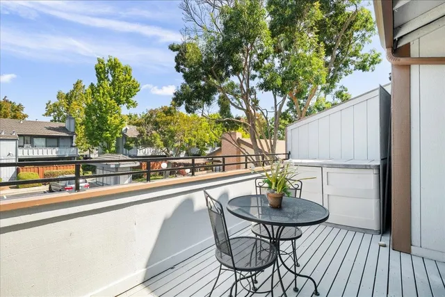 a view of a balcony with chairs and potted plants
