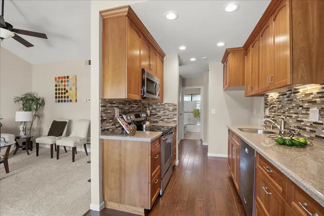 a kitchen with stainless steel appliances granite countertop a stove a sink and a refrigerator