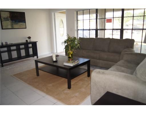 1651 North Cypress Road Pompano Beach, FL 33060 - Photo 2 of 12 a living room with furniture and a potted plant