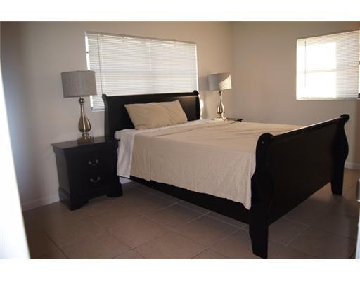 1651 North Cypress Road Pompano Beach, FL 33060 - Photo 6 of 12 a bed sitting in a bedroom next to a window