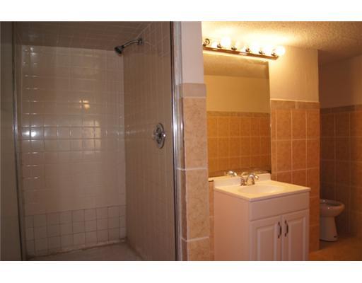 1651 North Cypress Road Pompano Beach, FL 33060 - Photo 7 of 12 a bathroom with a sink mirror and shower