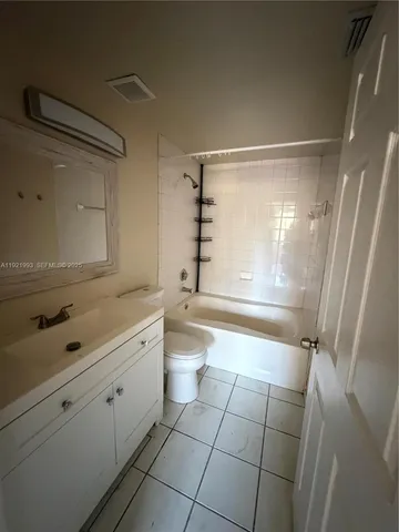 a bathroom with a granite countertop sink a toilet and shower