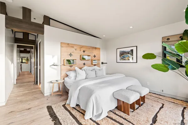 a bedroom with a bed and painting on the wall