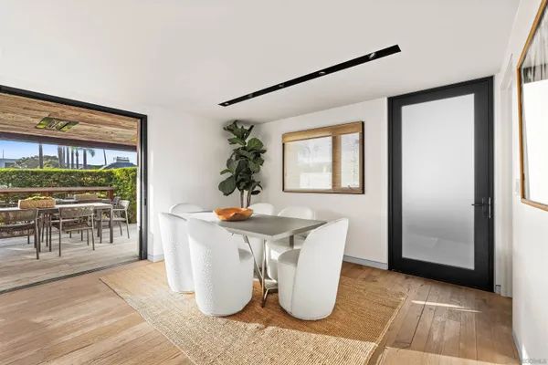a kitchen with kitchen island stainless steel appliances a dining table chairs and sink
