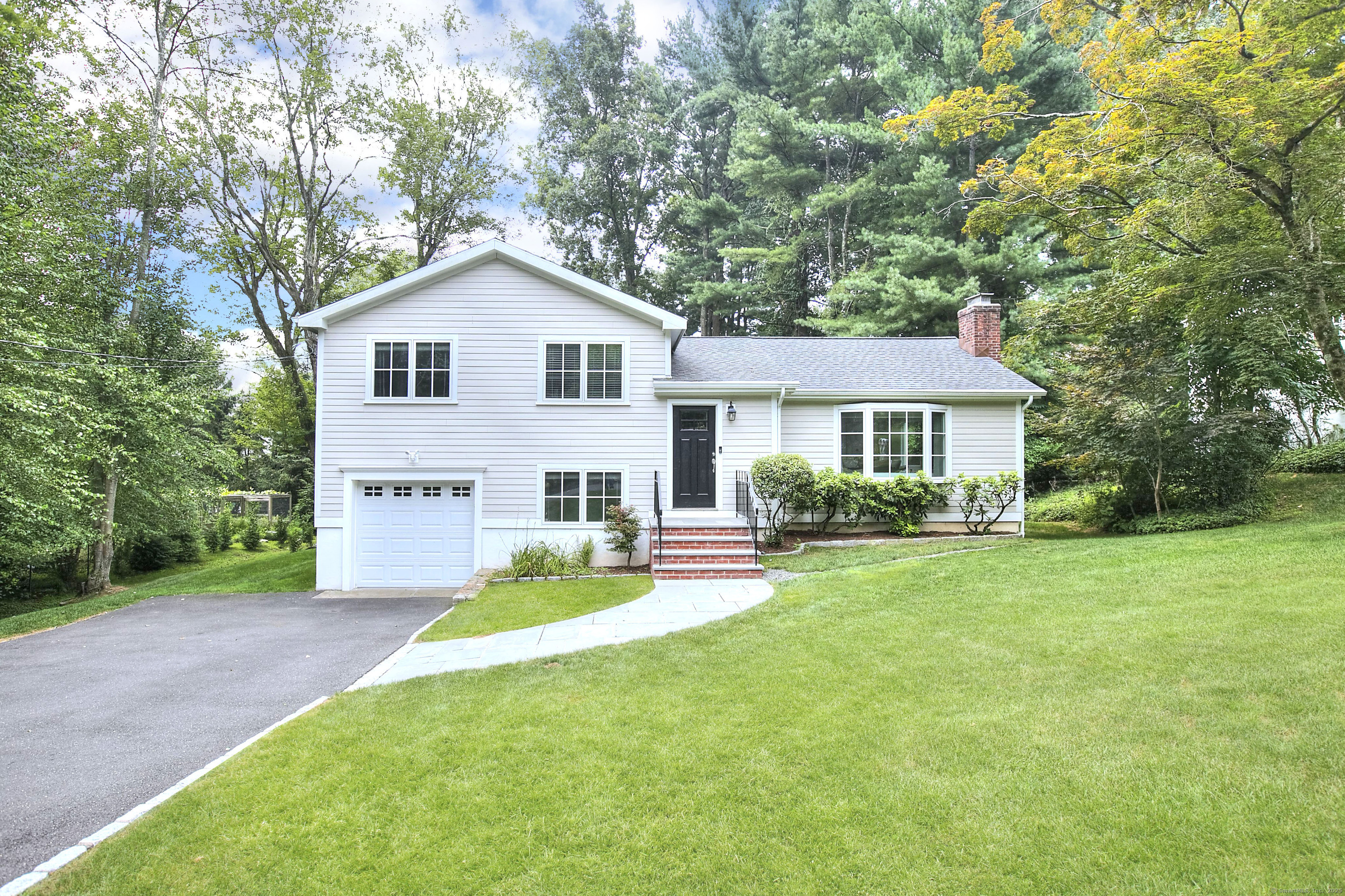a front view of a house with a yard and trees
