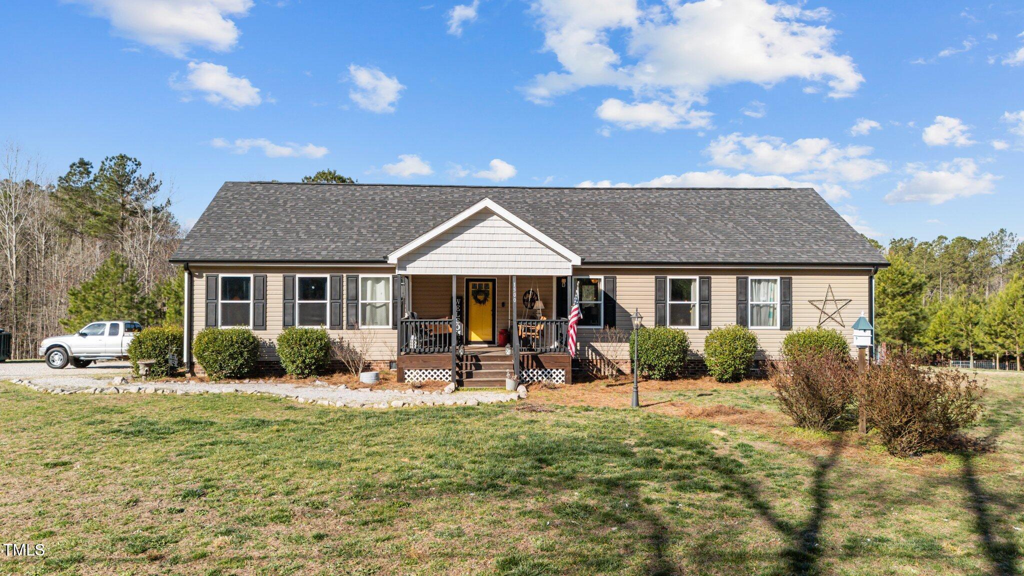 1500 Cheves Road Zebulon, NC 27597 - Photo 1 of 42 a front view of a house with garden and porch