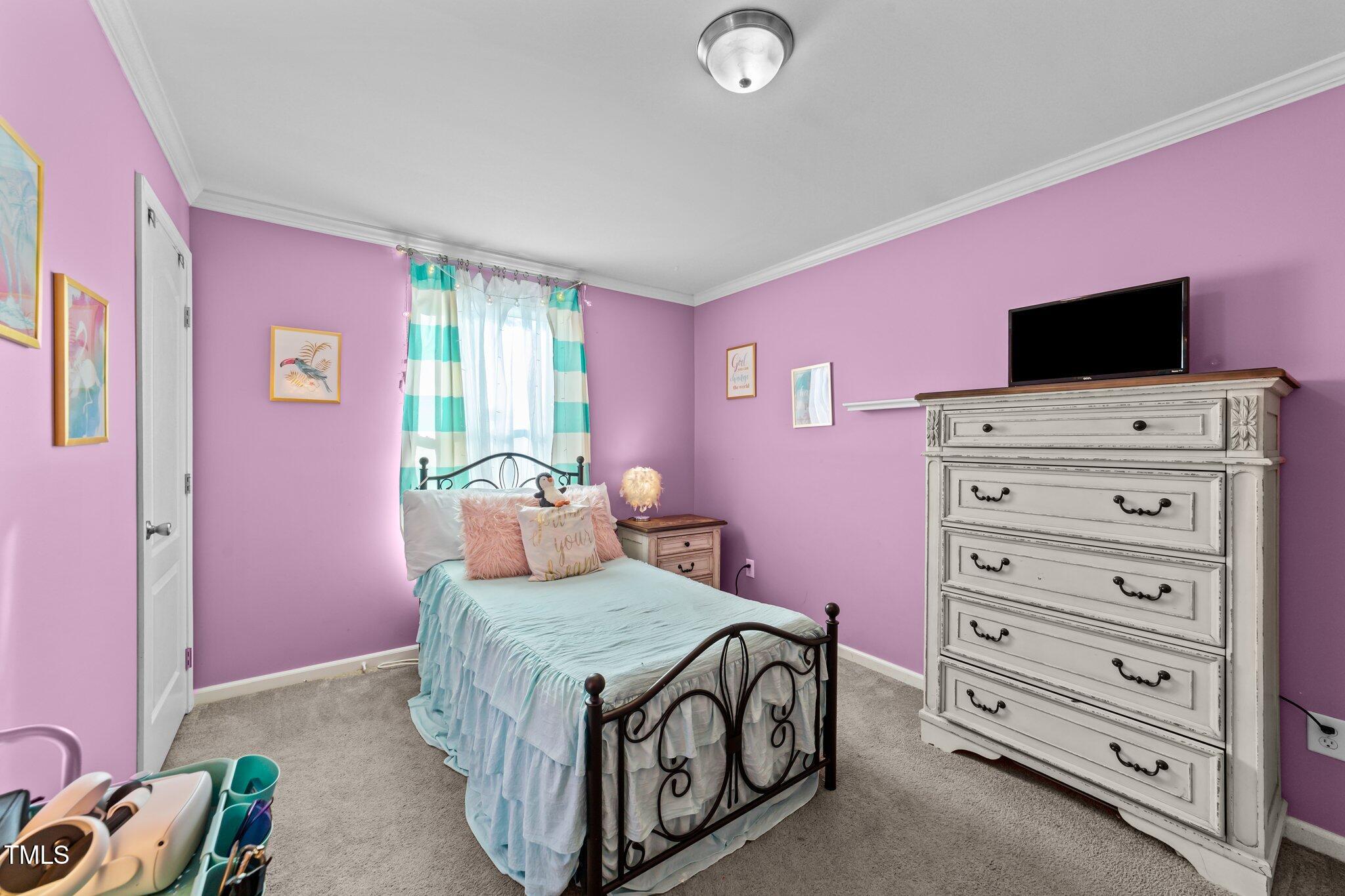 1500 Cheves Road Zebulon, NC 27597 - Photo 23 of 42 a bedroom with a bed and a flat screen tv
