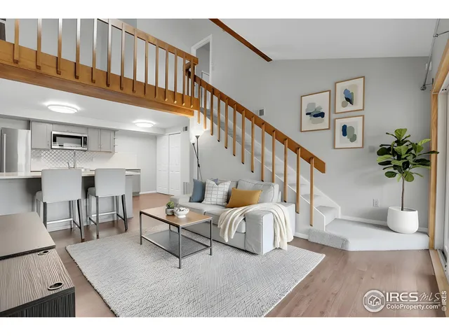 a living room with furniture flowerpot and wooden floor