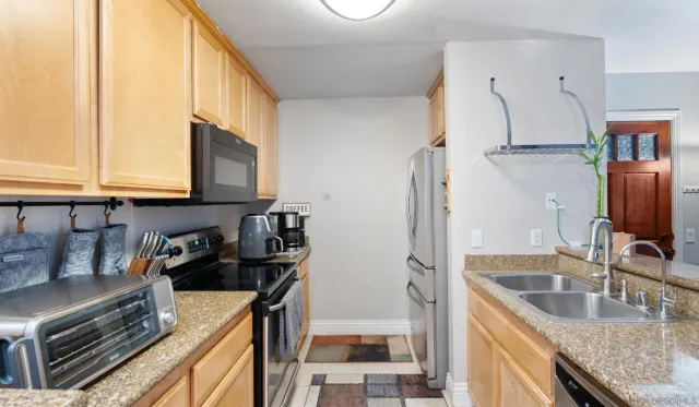 a kitchen with stainless steel appliances granite countertop a sink stove and refrigerator