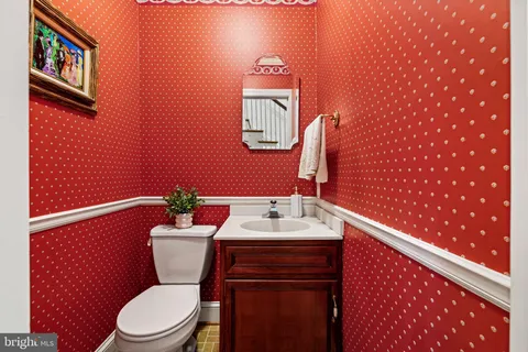 a bathroom with a toilet a sink and mirror