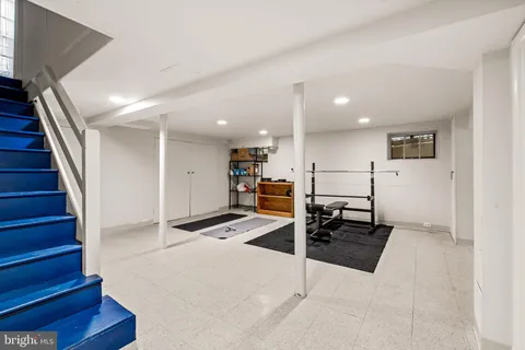 a room with gym equipment and wooden floor