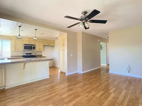 a kitchen with stainless steel appliances kitchen island a refrigerator sink and white cabinets