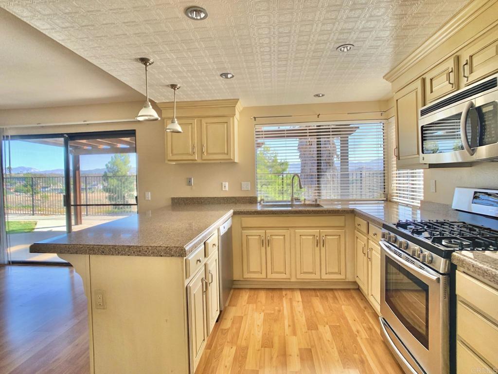 3331 Eton Greens Court Spring Valley, CA 91978 - Photo 13 of 39 a kitchen with stainless steel appliances granite countertop a sink and a stove