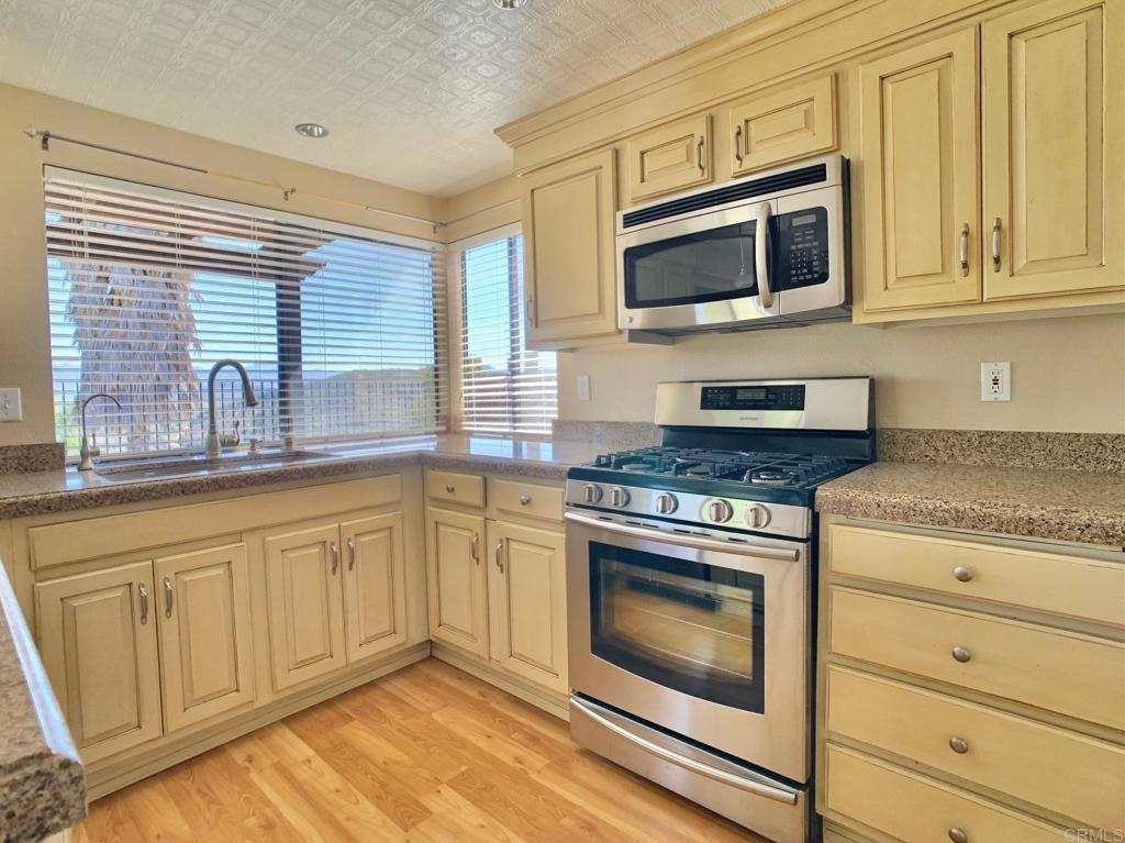 3331 Eton Greens Court Spring Valley, CA 91978 - Photo 14 of 39 a kitchen with granite countertop cabinets stainless steel appliances and a sink