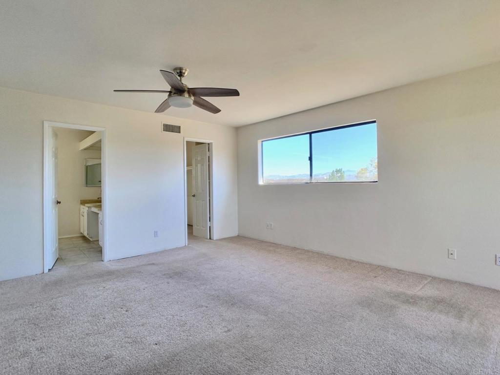 3331 Eton Greens Court Spring Valley, CA 91978 - Photo 23 of 39 an empty room with chandelier fan and windows