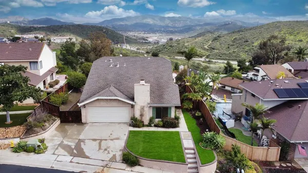 an aerial view of multiple houses with a yard