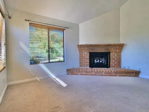 a view of an empty room with a fireplace and a window