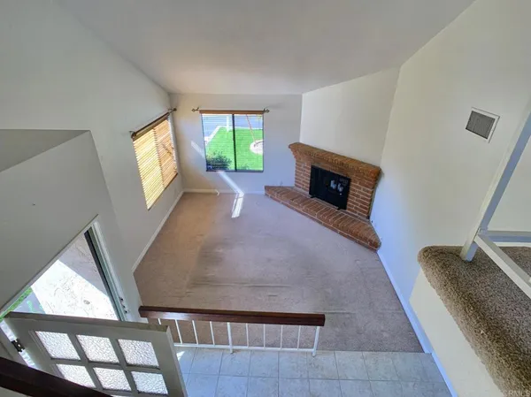 a view of a livingroom with wooden floor and a fireplace