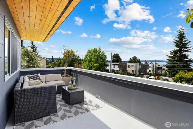 a roof deck with table and chairs and potted plants