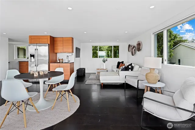 a living room with furniture a large window and a dining table
