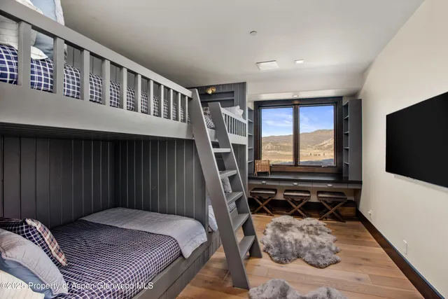 a bedroom with a bed and a flat tv screen on the dresser