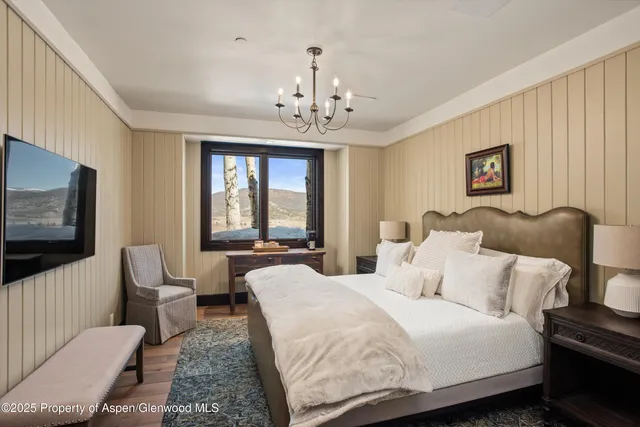 a spacious bedroom with a bed and a flat screen tv