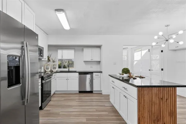 a kitchen with white cabinets and appliances