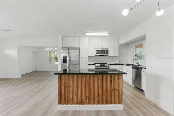 a kitchen with stainless steel appliances granite countertop a stove a sink dishwasher and a refrigerator