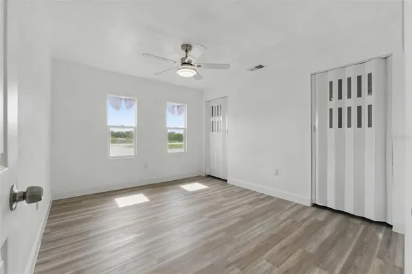 a view of an empty room with wooden floor