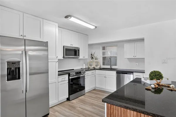 a kitchen with appliances a sink and cabinets