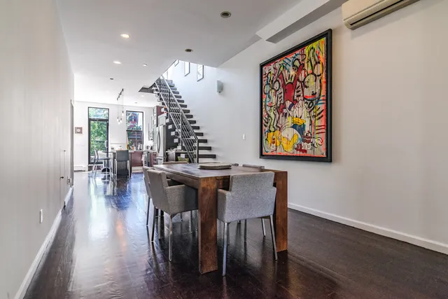 a view of a dining room with furniture wooden floor and a potted plant