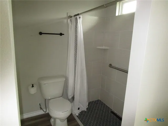 a white toilet sitting next to a shower