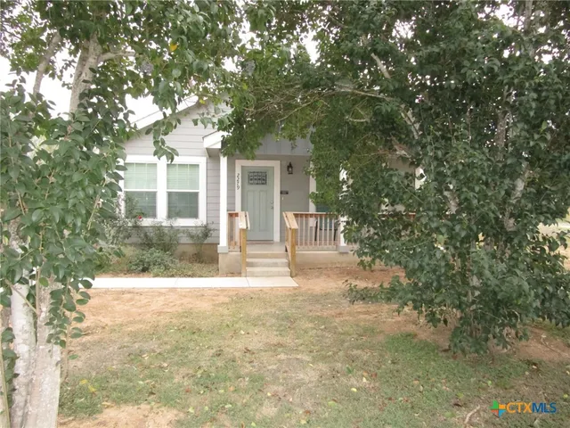 a front view of a house with yard and trees
