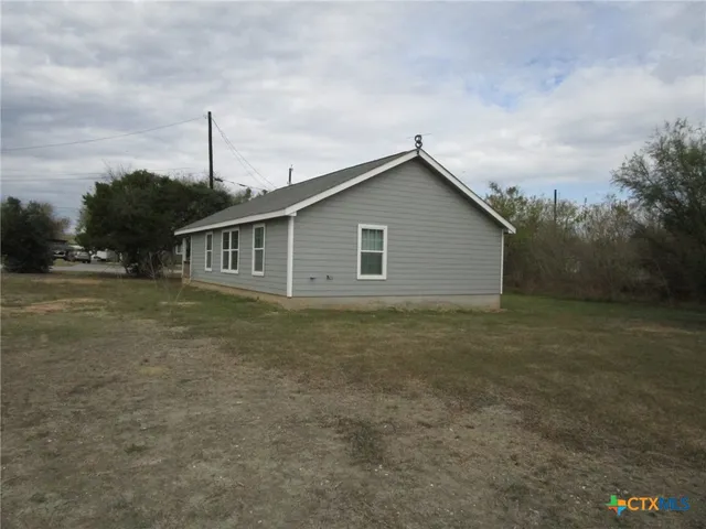 a view of a house with a backyard