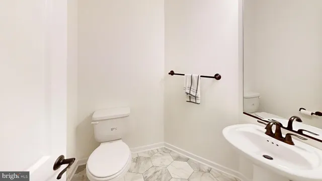 a bathroom with a sink a toilet and mirror