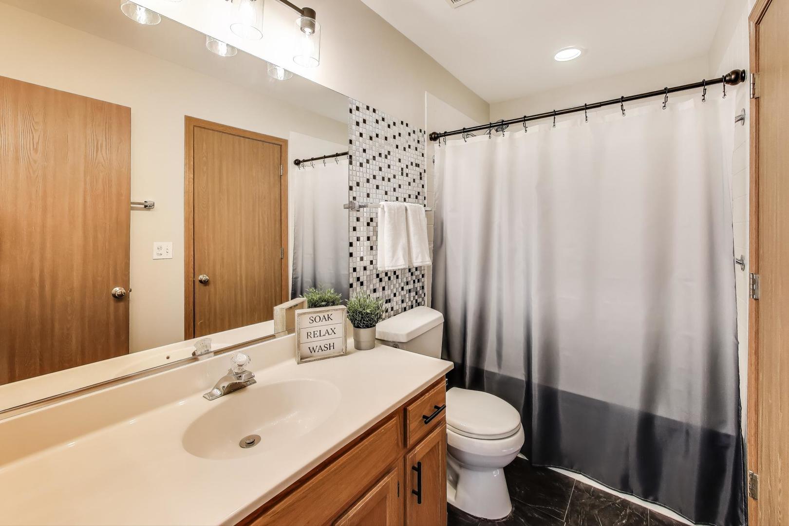 985 Manchester Circle, Unit 985 Grayslake, IL 60030 - Photo 13 of 17 a bathroom with a sink a toilet and shower curtain