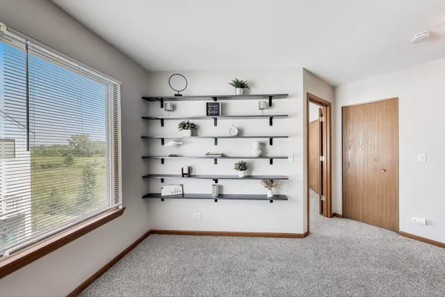 a view of an empty room with cabinet and mirrors