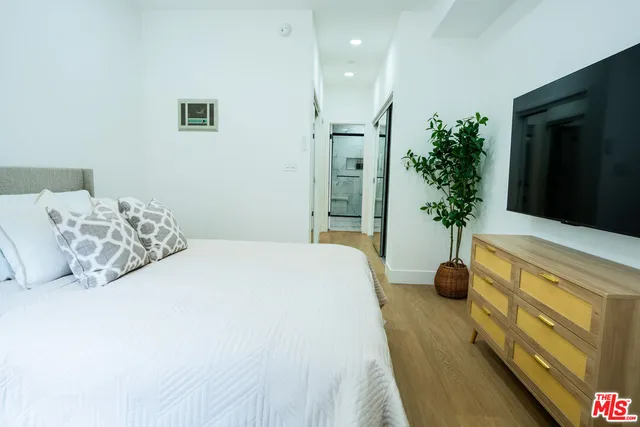 a bedroom with a bed and a potted plant