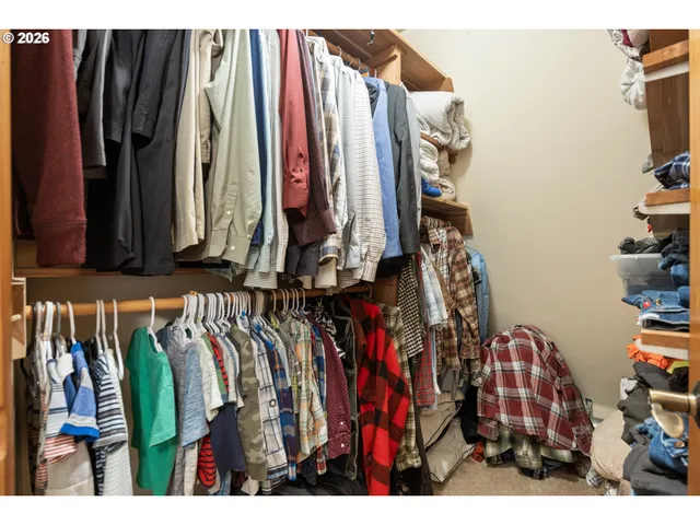 a view of walk in closet with clothes