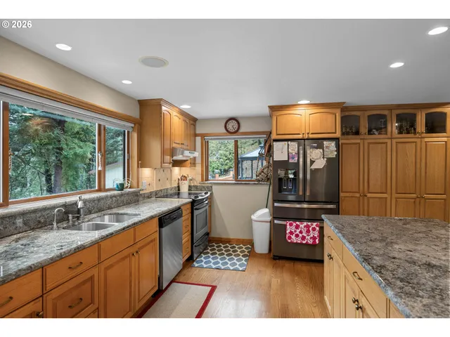 a kitchen with stainless steel appliances granite countertop a sink and a wooden cabinets